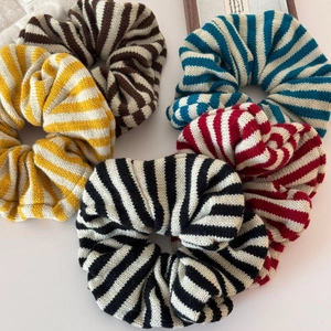 Detailed set of five striped knit oversized scrunchies in various cozy autumn colors