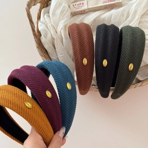 Detailed view of knitted wide headbands with gold Korea label in various colors