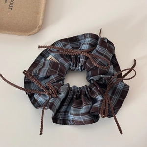 Detail view of plaid bow scrunchie with blue brown check fabric and woven ties
