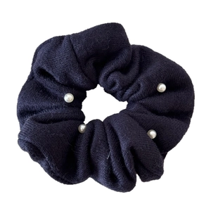 Navy blue knitted scrunchie with white pearl accents and elastic fabric texture