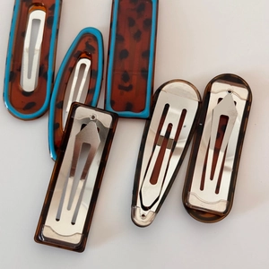 Detail view of leopard print hair clips with blue trim and metal spring clips