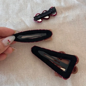 Detail view of the black velvet backing and metal clips on red plaid hair accessories