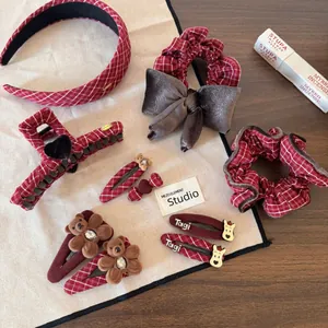 Flat lay of vintage red plaid hair accessories set with velvet bows and cute bear clips