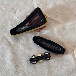 Detailed back view of brown plaid hair clips showing metal buckles and fabric craftsmanship
