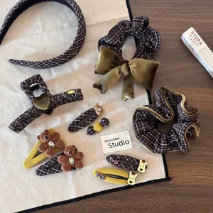 Detail view of brown plaid hair accessories set with teddy bear and velvet bow accents