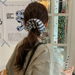 Blue and white striped knit oversized scrunchie shown on a low ponytail hair tie style