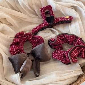Detail showing red and white plaid hair claw with brown velvet heart and scrunchies