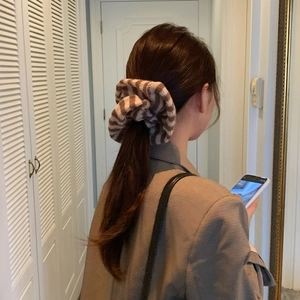 Close-up of oversized striped fabric scrunchie with knit texture worn on ponytail