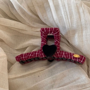 Detail of red plaid hair claw clip with black heart and gold engraved metal plaque