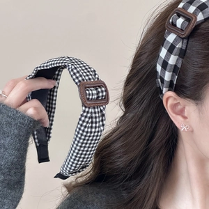 Serre-tête vintage à carreaux noir et blanc avec boucle marron présenté sur modèle