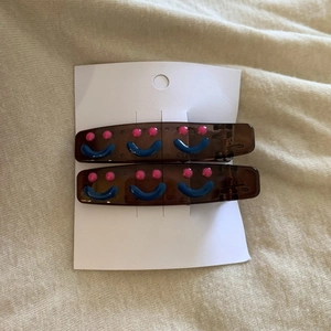 Close-up of translucent brown hair clips with colorful smiley face on display card