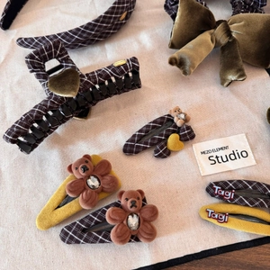 Brown plaid hair accessories set with teddy bear clips and velvet bow on beige linen