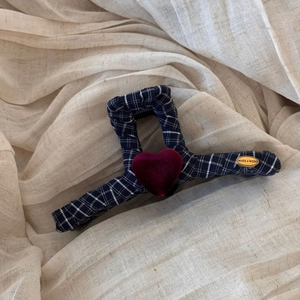 Detail of navy plaid hair claw clip with velvet heart and golden metal wish tag