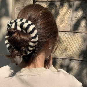 Close-up of black and white striped oversized knit scrunchie on a hair bun