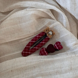 Macro shot of red plaid hair clips with a cute plush bear and heart-shaped fabric designs