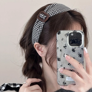Gros plan du serre-tête rétro à carreaux noir et blanc avec boucle carrée vintage