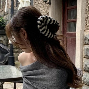 Detail showing the knitted texture of the oversized black and white striped hair scrunchie
