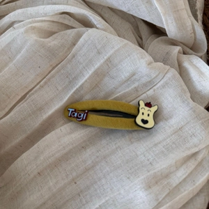 Detail of warm yellow fabric hair clip with Tagi embroidery and cute cartoon bear