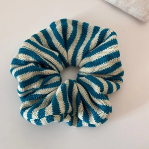 Close-up of blue and white striped knitted scrunchie showing detailed woven texture