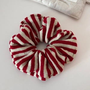 Close-up detail of oversized knit scrunchie with red and white striped pattern texture