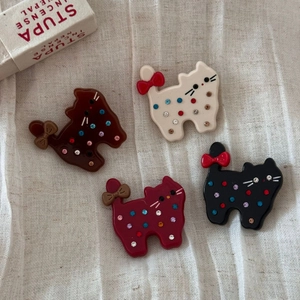 Détail de quatre barrettes chat en acétate coloré avec strass et nœuds papillon