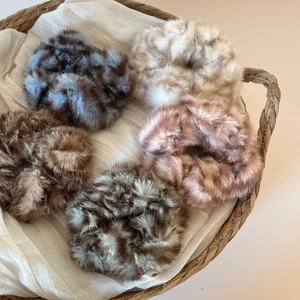 Détail d'un lot de 5 chouchous en peluche léopard et unis dans un panier tressé
