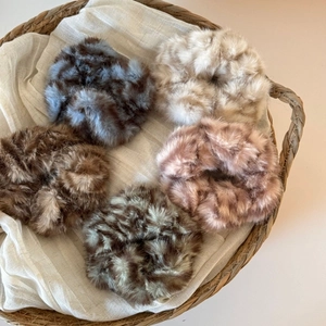 Détail de cinq chouchous en peluche surdimensionnés aux couleurs assorties pour l'hiver