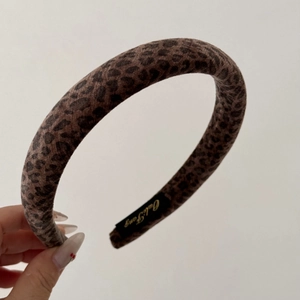 Gros plan du serre-tête léopard en velours avec détail de l'étiquette intérieure