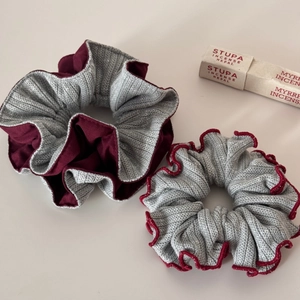 Detail of grey and deep red double-layered knitted scrunchies with soft texture