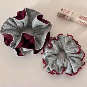 Close-up of gray knitted and burgundy fabric scrunchies in a stylish two-piece set