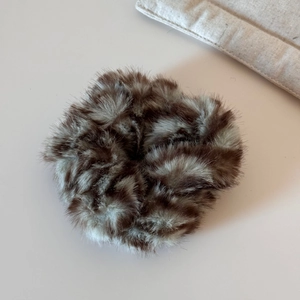 Gros plan sur un chouchou en peluche douce aux textures moelleuses marron et beige