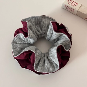 Detail of two-tone burgundy and grey oversized scrunchie with layered fabric texture