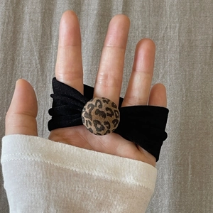 Elastic black fabric hair tie featuring a stylish leopard print round charm detail
