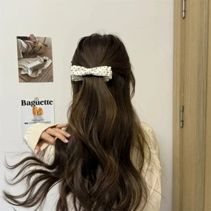 Polka dot bow banana clip for thick hair shown on a woman styling a high ponytail
