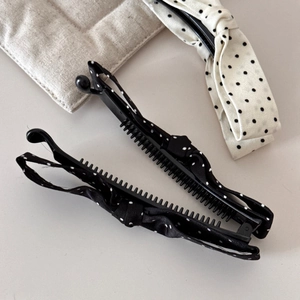 Close-up of banana clips featuring retro polka dot bow fabric and sturdy black teeth