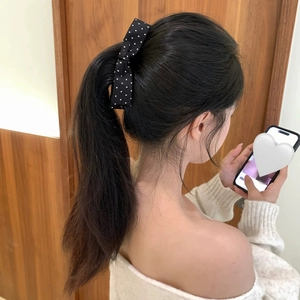 Rear view showing black and white polka dot bow hair clip on high ponytail hair