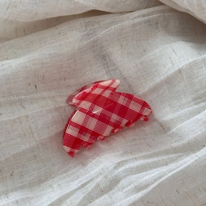 Macro detail of red and cream checkered pattern on the acetate hair claw clip