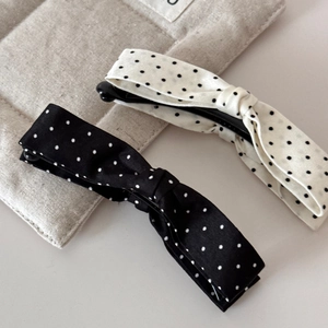 Detailed view of the fabric texture and classic polka dot patterns on the bow banana clips