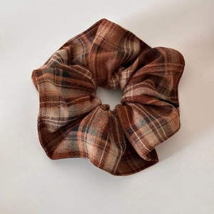 Vue détaillée du chouchou vintage à carreaux marron avec texture de tissu écossais