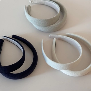Detailed view of padded sponge headbands showing handmade labels and woven fabric texture