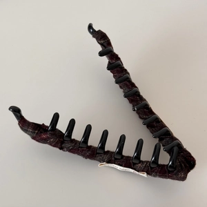 Detail of the vintage plaid tweed fabric and V-shaped shark clip with polished black teeth