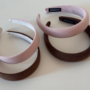 Detail view of pink and brown sponge headbands with handmade woven texture and fabric label