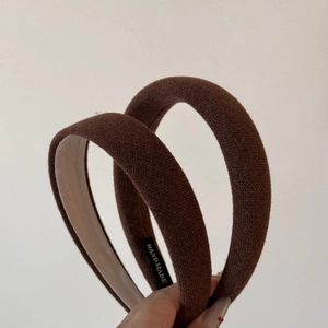 Detail view of the brown knitted texture and handmade label on the padded headband