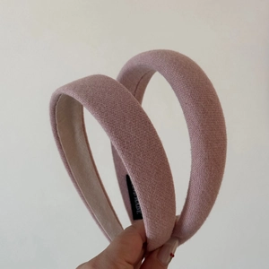Close-up of pink padded sponge headband featuring a handmade label and fabric texture