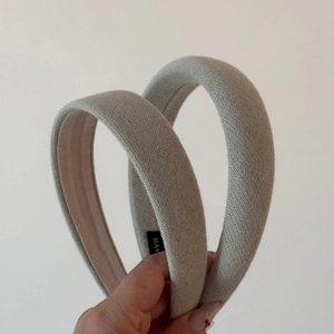 Detail showing the thick light gray fabric texture and hand-held knit padded headband