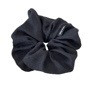 Large black striped fabric scrunchie with a handmade tag on a clean white background
