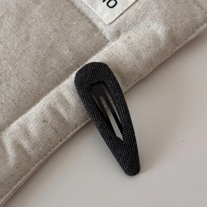 Gros plan sur la barrette BB en tissu à chevrons gris foncé au design en forme de goutte