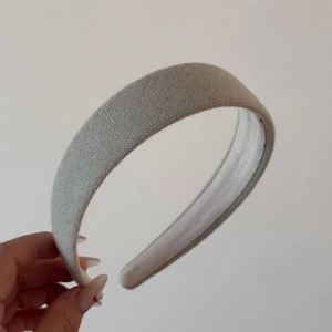 Detail of light grey knit padded headband with smooth white inner lining for hair styling