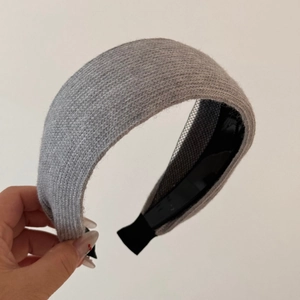 Detailed close-up of light gray knitted headband with non-slip interior and thick texture