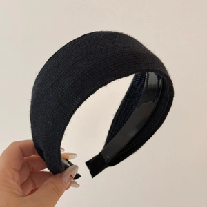 Detail of black knitted wide headband featuring non-slip inner teeth for secure grip